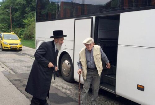 The Veitzen Rebbe shlita greets people arriving on chartered bus.